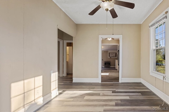 spare room featuring plenty of natural light, hardwood / wood-style floors, and a textured ceiling