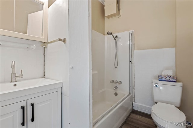 full bathroom featuring wood-type flooring, toilet, shower / bath combination with glass door, vanity, and tile walls