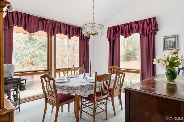 carpeted dining area featuring vaulted ceiling and a notable chandelier