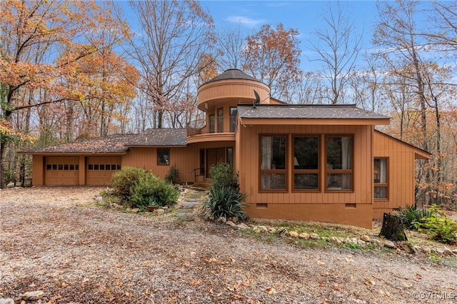 view of front of property featuring a garage and a balcony