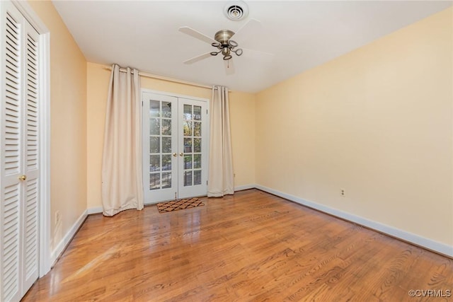 empty room featuring ceiling fan, light hardwood / wood-style floors, and french doors