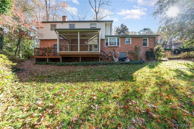 back of property with a yard, a sunroom, and a deck