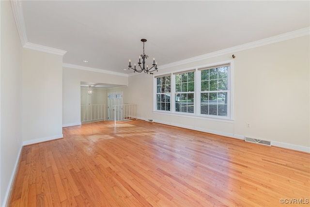 interior space featuring an inviting chandelier, crown molding, and light hardwood / wood-style floors