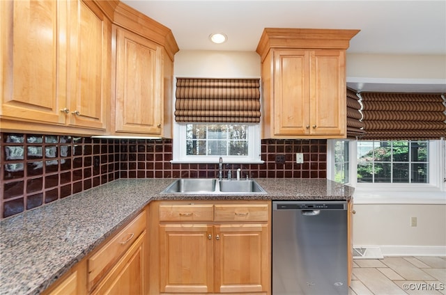 kitchen with sink, light tile patterned floors, dishwasher, stone counters, and backsplash