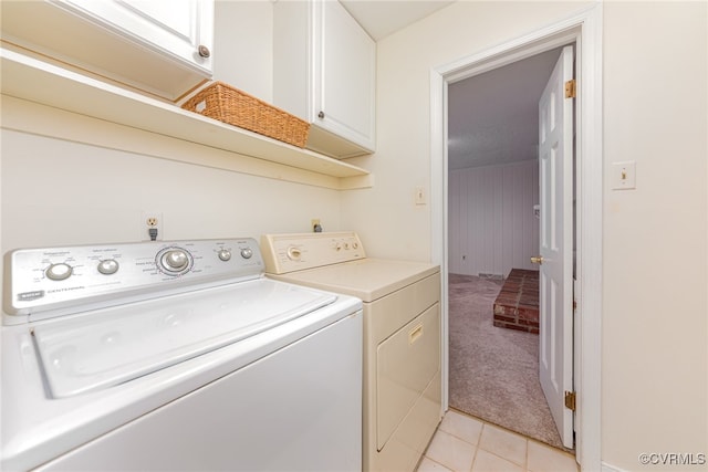 washroom with cabinets, light colored carpet, and washer and clothes dryer