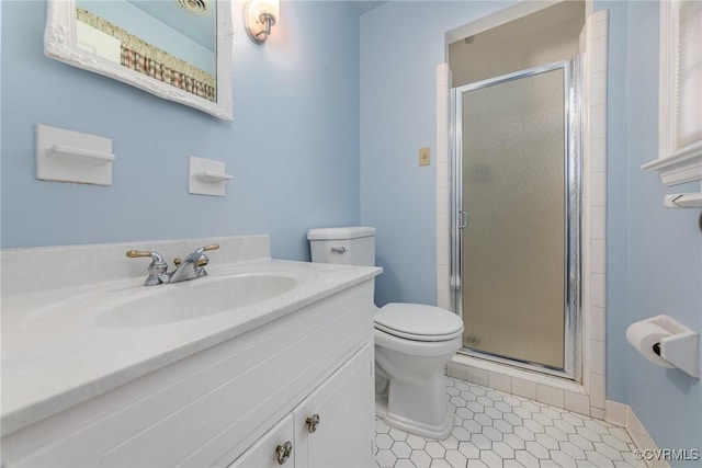 bathroom with a shower with door, vanity, tile patterned flooring, and toilet