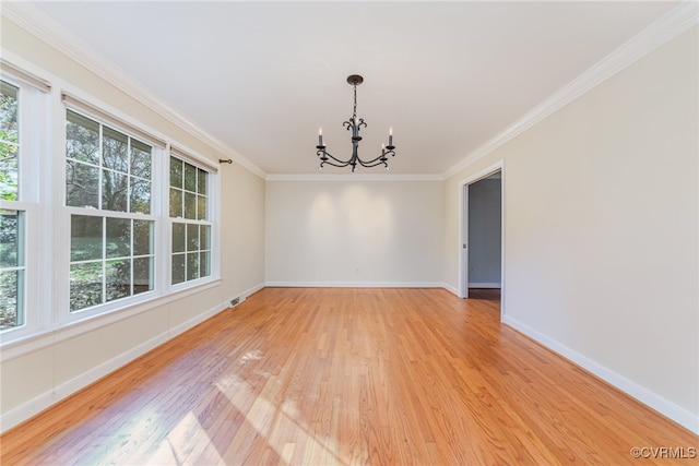 unfurnished dining area featuring an inviting chandelier, crown molding, and hardwood / wood-style floors