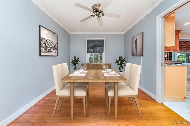 dining space with a wealth of natural light, ornamental molding, and light wood-type flooring