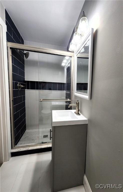 bathroom with vanity and a shower with door