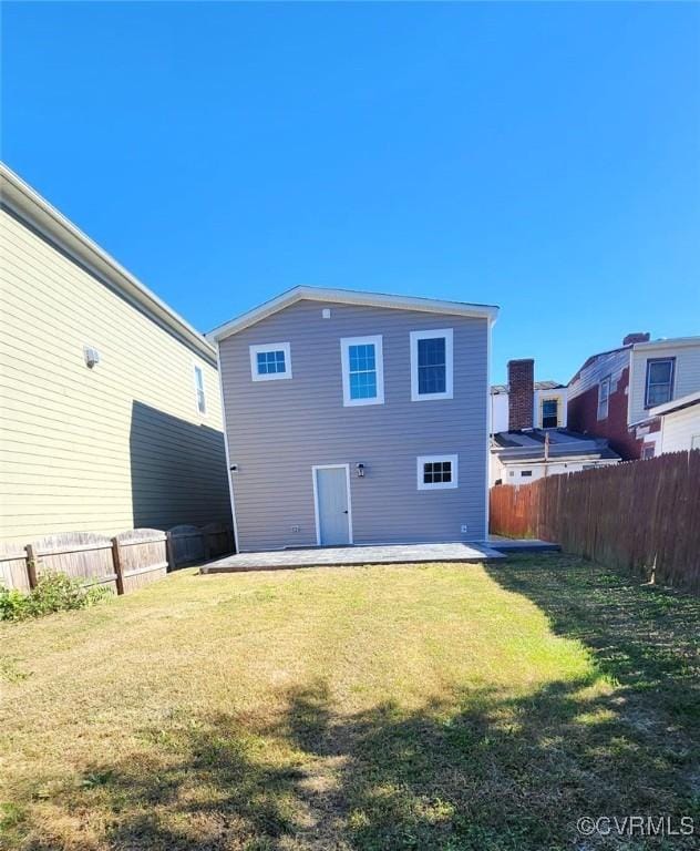 rear view of house featuring a yard and a patio