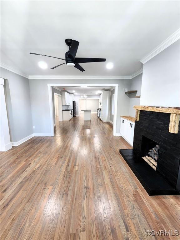 unfurnished living room with hardwood / wood-style floors, ceiling fan, and ornamental molding