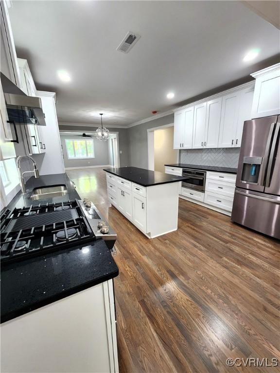 kitchen featuring white cabinets, dark hardwood / wood-style flooring, stainless steel appliances, and an inviting chandelier