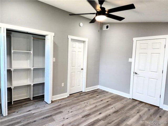 unfurnished bedroom with ceiling fan, hardwood / wood-style floors, and vaulted ceiling