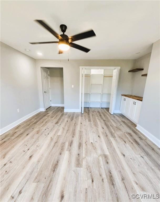 unfurnished living room with light wood-type flooring and ceiling fan