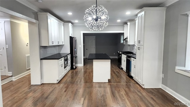 kitchen featuring decorative light fixtures, dark hardwood / wood-style flooring, white cabinetry, and appliances with stainless steel finishes