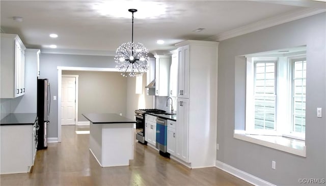 kitchen with an inviting chandelier, crown molding, hanging light fixtures, appliances with stainless steel finishes, and white cabinetry