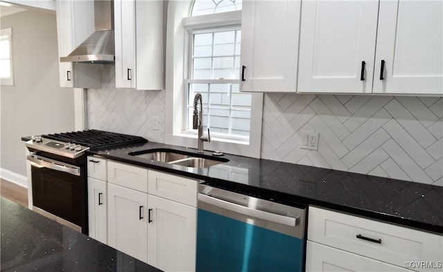 kitchen featuring sink, white cabinets, wall chimney range hood, and appliances with stainless steel finishes