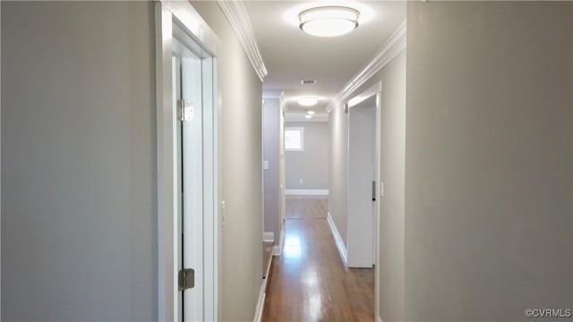 hallway with light hardwood / wood-style floors and ornamental molding