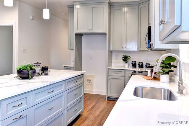 3557 Odi St, West Point, VA 23181 - kitchen featuring gray cabinetry, pendant lighting, wood finished floors, light stone counters, and stainless steel microwave