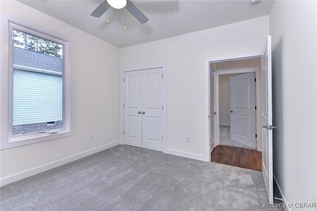 unfurnished bedroom with carpet flooring, ceiling fan, and a closet