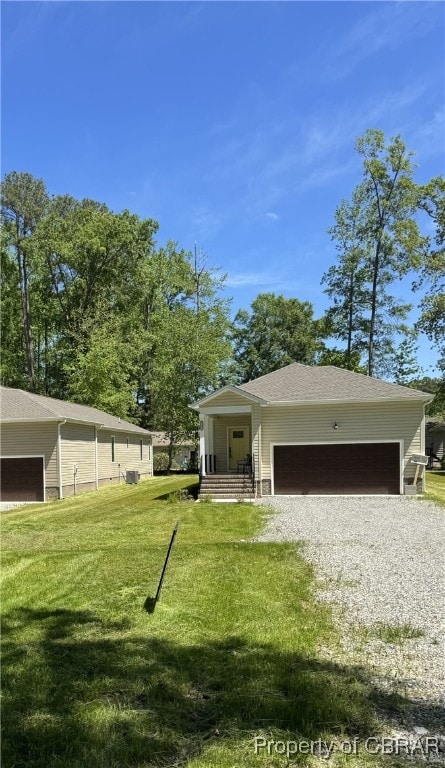 3557 Odi St, West Point, VA 23181 - view of front facade featuring a front yard, driveway, an attached garage, and a shingled roof