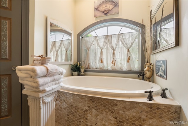 bathroom with a relaxing tiled tub