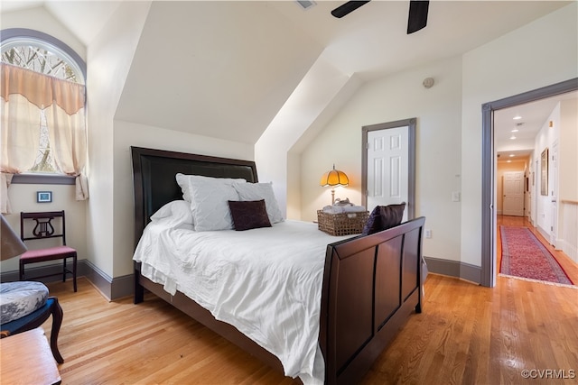 bedroom featuring ceiling fan, light hardwood / wood-style flooring, and lofted ceiling