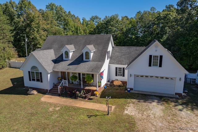 new england style home featuring a front lawn, a garage, and covered porch