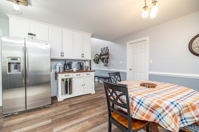 kitchen featuring white cabinets, hardwood / wood-style floors, stainless steel fridge with ice dispenser, and wood counters