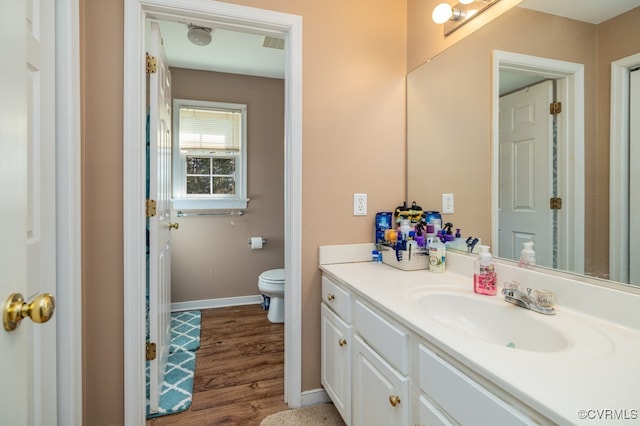 bathroom featuring toilet, vanity, and hardwood / wood-style flooring