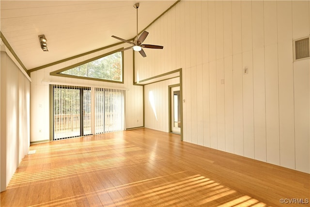 interior space with hardwood / wood-style flooring, high vaulted ceiling, wooden walls, and ceiling fan