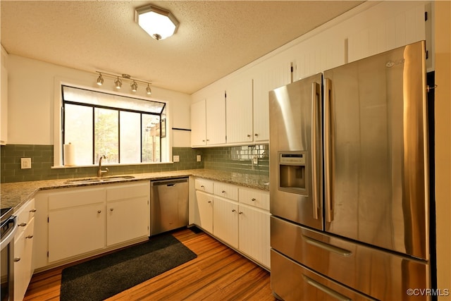 kitchen with light hardwood / wood-style flooring, white cabinetry, sink, and stainless steel appliances