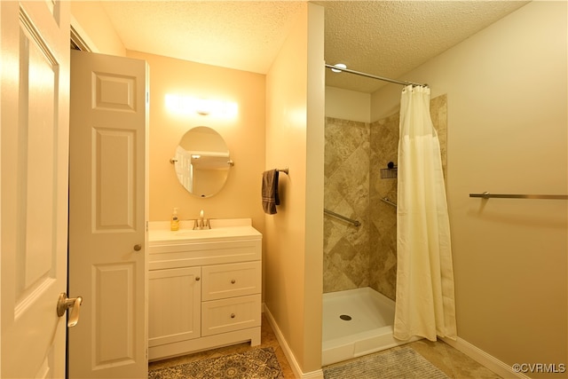 bathroom with vanity, a shower with shower curtain, and a textured ceiling