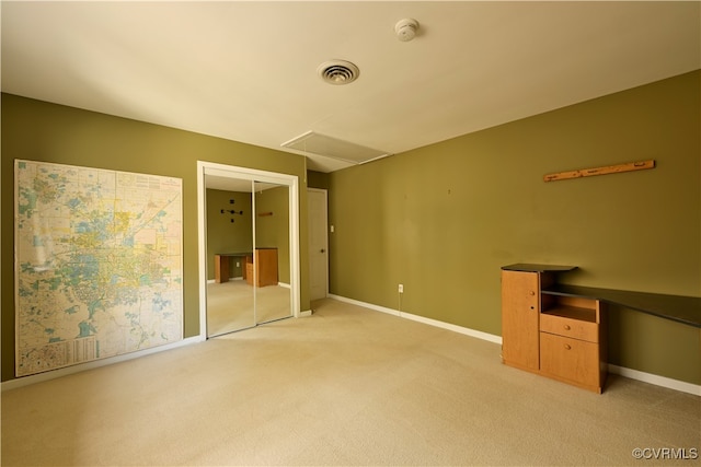 unfurnished bedroom featuring light colored carpet and a closet