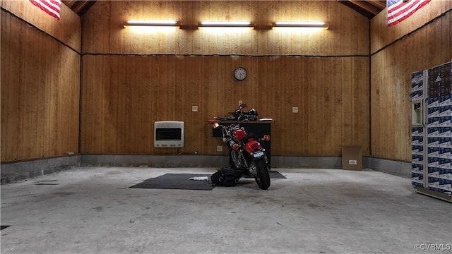 garage featuring heating unit and wooden walls