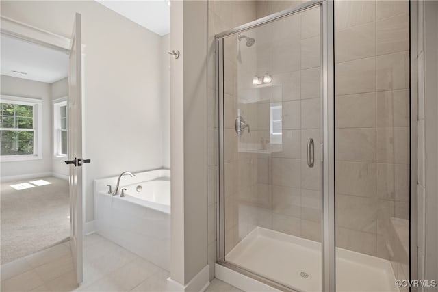 bathroom featuring tile patterned flooring and shower with separate bathtub