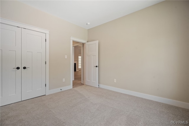 unfurnished bedroom featuring light colored carpet and a closet