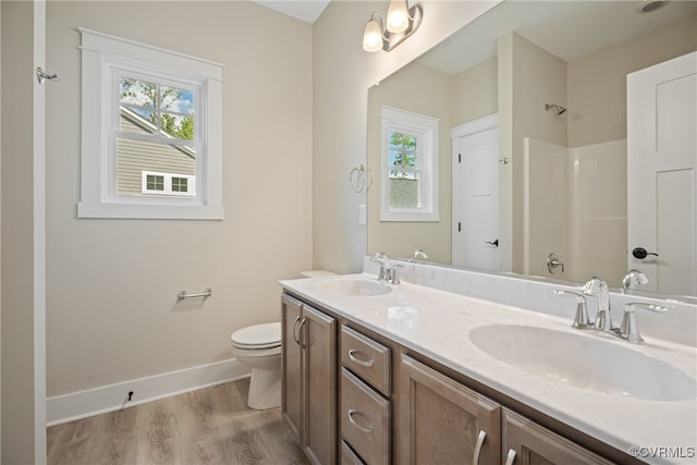 bathroom featuring wood-type flooring, vanity, and toilet