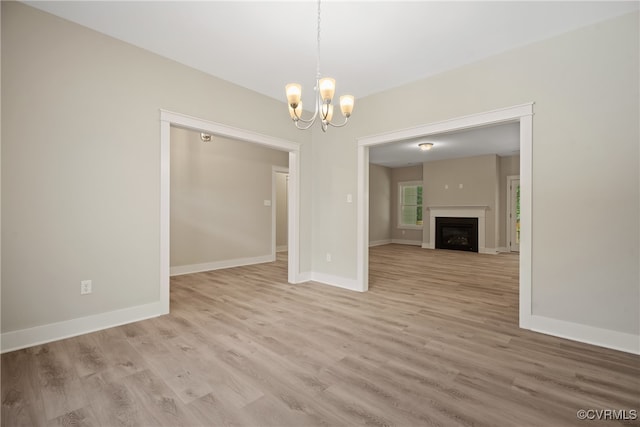 unfurnished dining area with light hardwood / wood-style floors and a chandelier