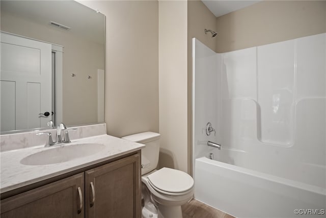 full bathroom with hardwood / wood-style floors, vanity, bathing tub / shower combination, and toilet