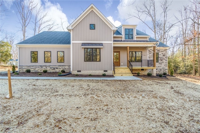 rear view of property with a shingled roof, board and batten siding, covered porch, and crawl space