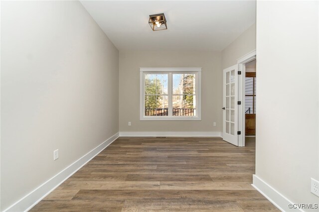 unfurnished room featuring baseboards and wood finished floors