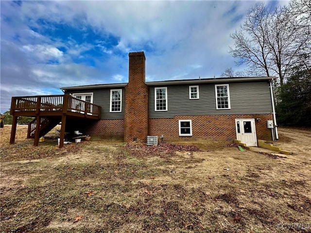 rear view of property featuring a wooden deck and central air condition unit