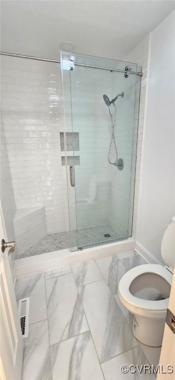 bathroom with a shower with door and toilet