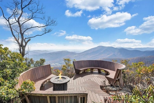 wooden deck featuring a fire pit and a mountain view