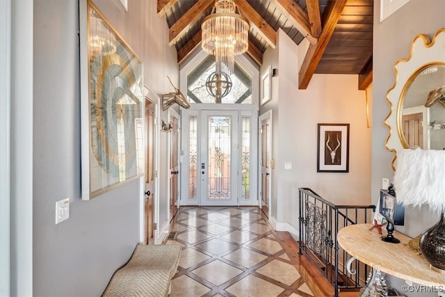 entrance foyer with beamed ceiling, wood ceiling, high vaulted ceiling, and an inviting chandelier