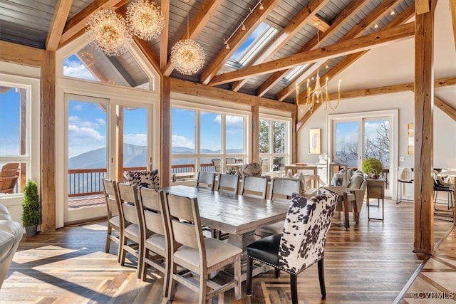 sunroom / solarium featuring a chandelier, vaulted ceiling with beams, a mountain view, and wooden ceiling