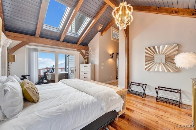 bedroom featuring access to outside, vaulted ceiling with skylight, wood ceiling, and hardwood / wood-style flooring