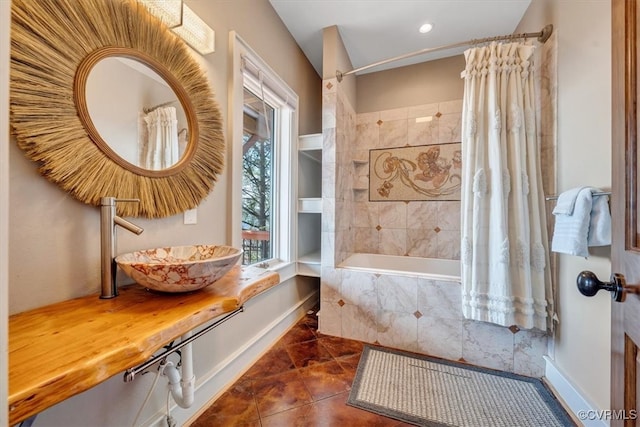 bathroom featuring shower / bathtub combination with curtain and sink