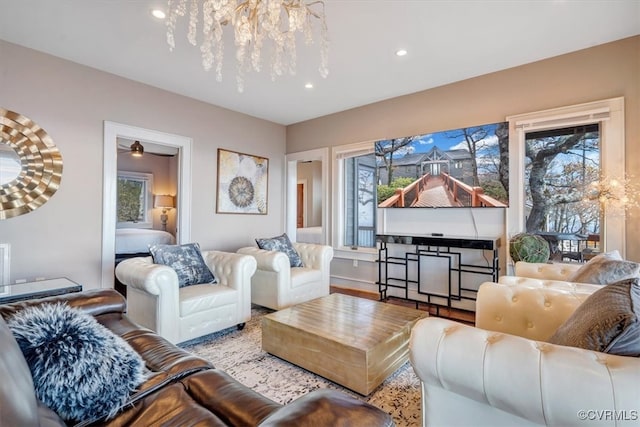 living room featuring plenty of natural light, light hardwood / wood-style floors, and an inviting chandelier